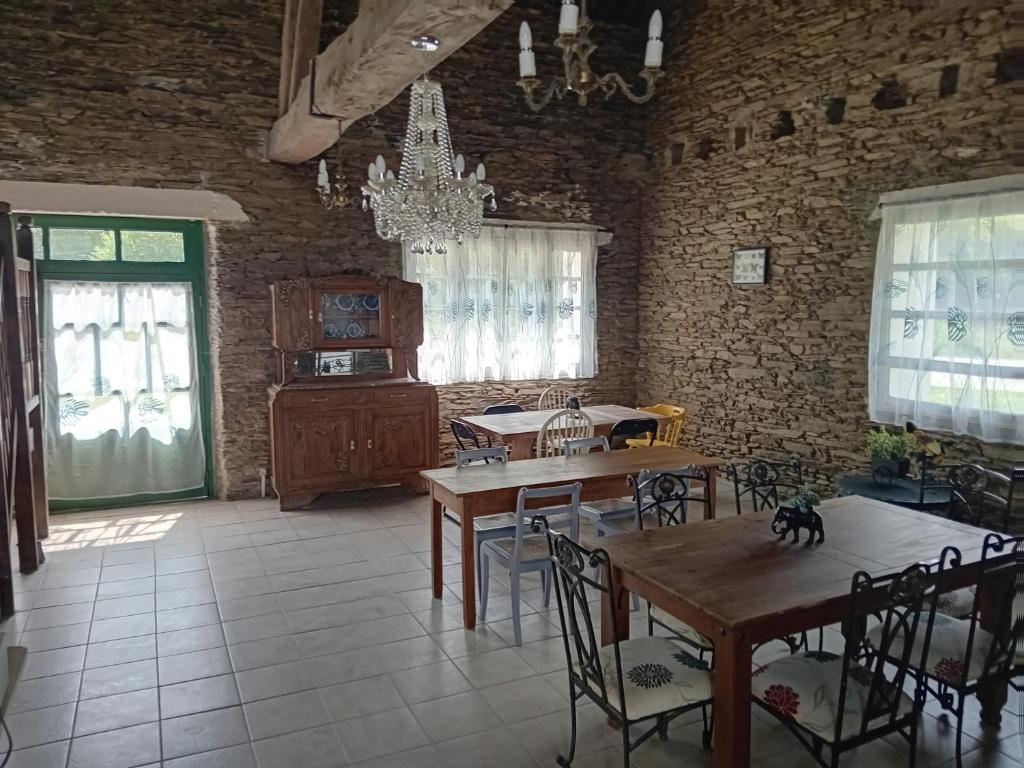 une salle à manger avec des tables et des chaises et un mur en briques dans l'établissement Luxury Glamping @Moulin des Forges, à Moutier-Malcard