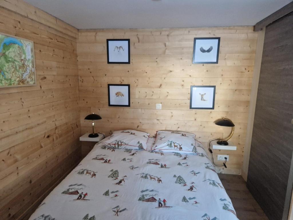 une chambre avec un lit dans un mur en bois dans l'établissement La Duchère 6 personnes Le Plan La Giettaz, à La Giettaz