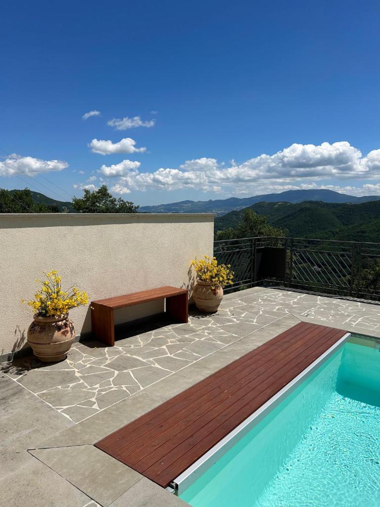 un patio avec un banc et une piscine dans l'établissement Poggio Ancisa Relais, à Casteldelci