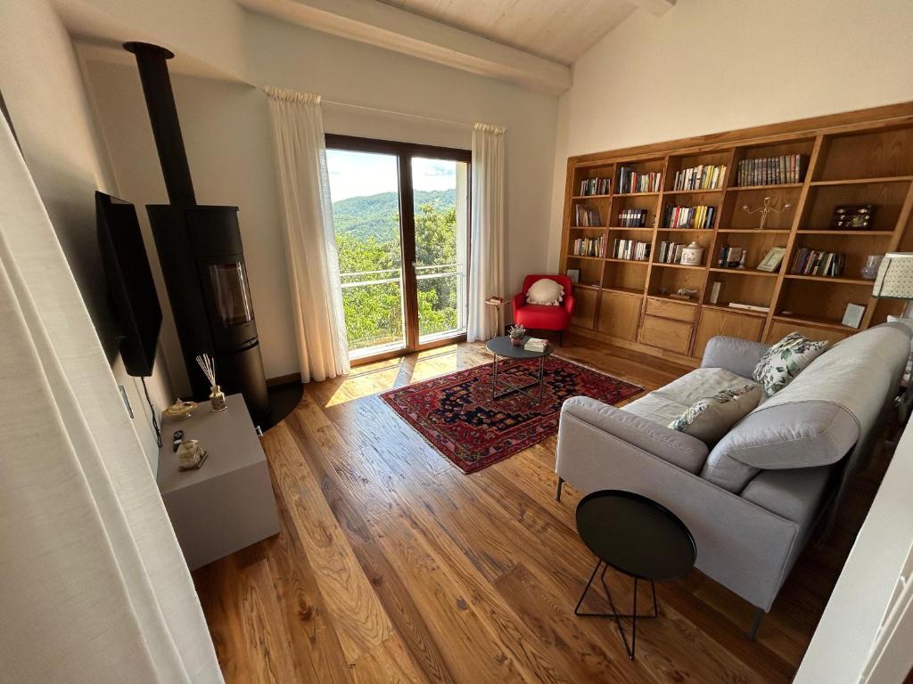 un salon avec un canapé et une grande fenêtre dans l'établissement Poggio Ancisa Relais, à Casteldelci