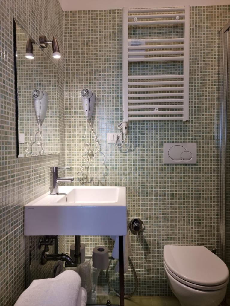 une salle de bain avec un lavabo et des toilettes dans l'établissement Hotel Morena, à Lido di Jesolo