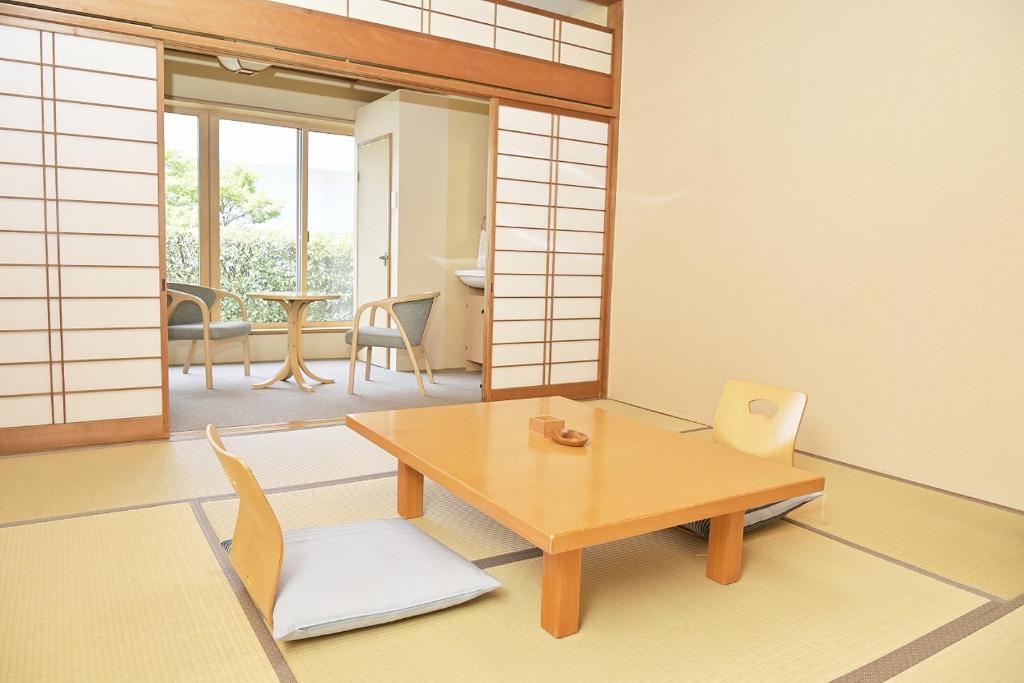 un salon avec une table et des chaises en bois dans l'établissement Kansuitei Kozeniya, à Tottori