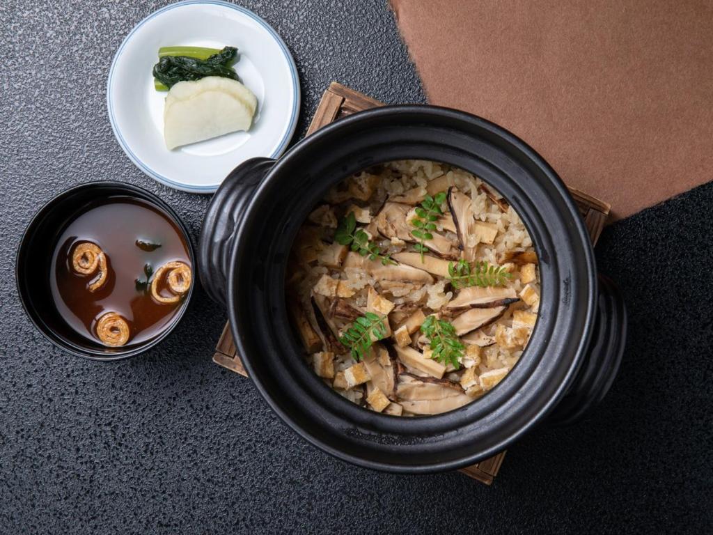 un bol de soupe noir avec une assiette de nourriture dans l'établissement Chousenkaku Kameya, à Shimo-suwa