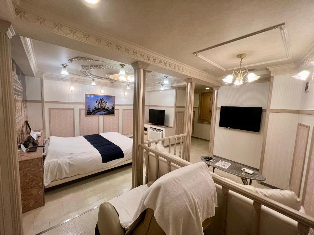 une chambre d'hôtel avec un lit et une télévision dans l'établissement T's Resort HAMAMATSU, à Hamamatsu