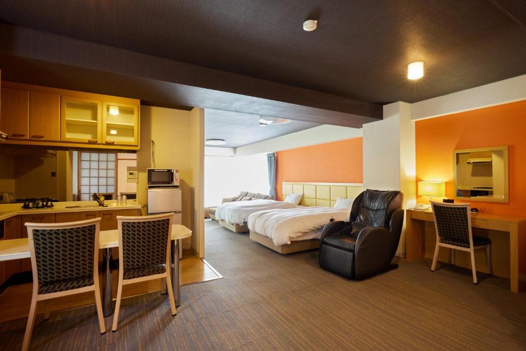 une chambre d'hôtel avec un lit, une table et des chaises dans l'établissement Reyzenit Kinosaki Suite VILLA, à Toyooka