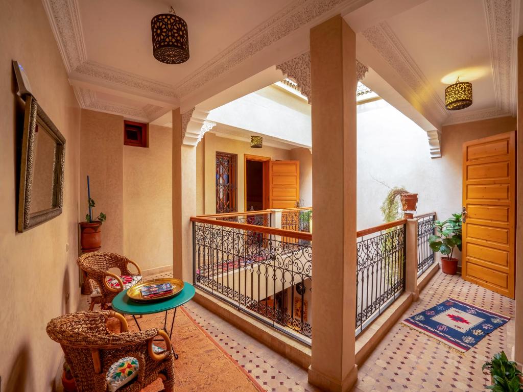 une chambre avec un balcon avec une table et des chaises dans l'établissement Riad Majdoulina chez JIJI, à Marrakech