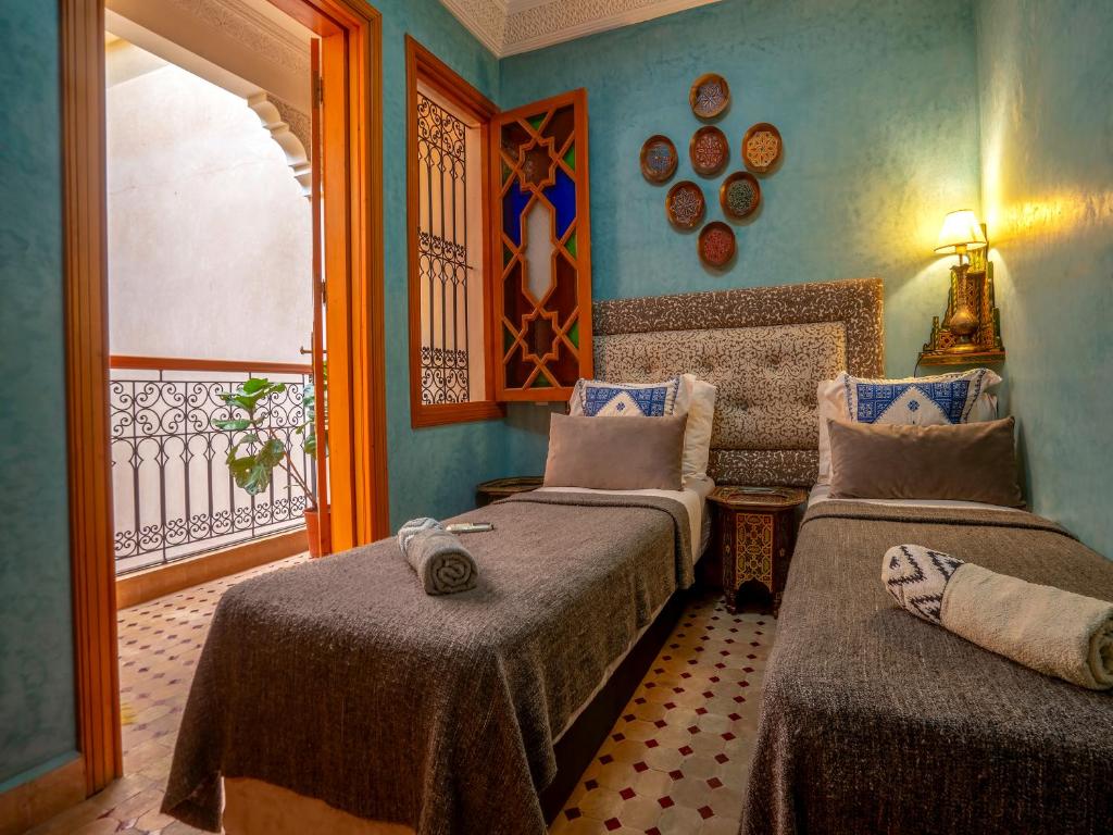 une chambre avec deux lits et un balcon dans l'établissement Riad Majdoulina chez JIJI, à Marrakech