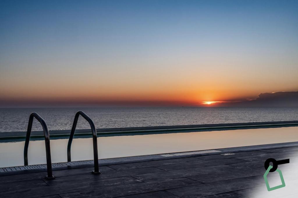 d'un balcon offrant une vue sur l'océan au coucher du soleil. dans l'établissement HOTIDAY Room Collection - Tirrenia, à Tirrenia