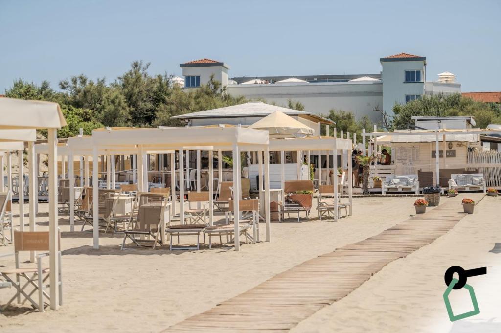 une plage avec des chaises et des parasols sur le sable dans l'établissement HOTIDAY Room Collection - Tirrenia, à Tirrenia