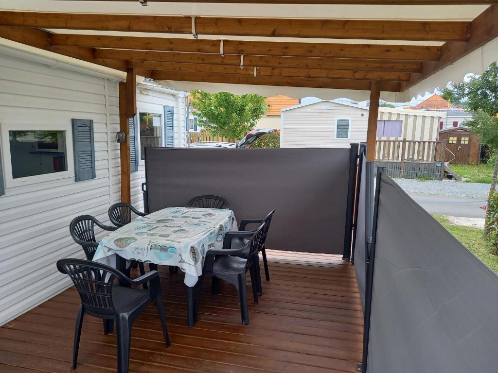 un patio avec une table et des chaises sur une terrasse dans l'établissement mobil home camping 3 etoiles les ollivaud, à La Baule