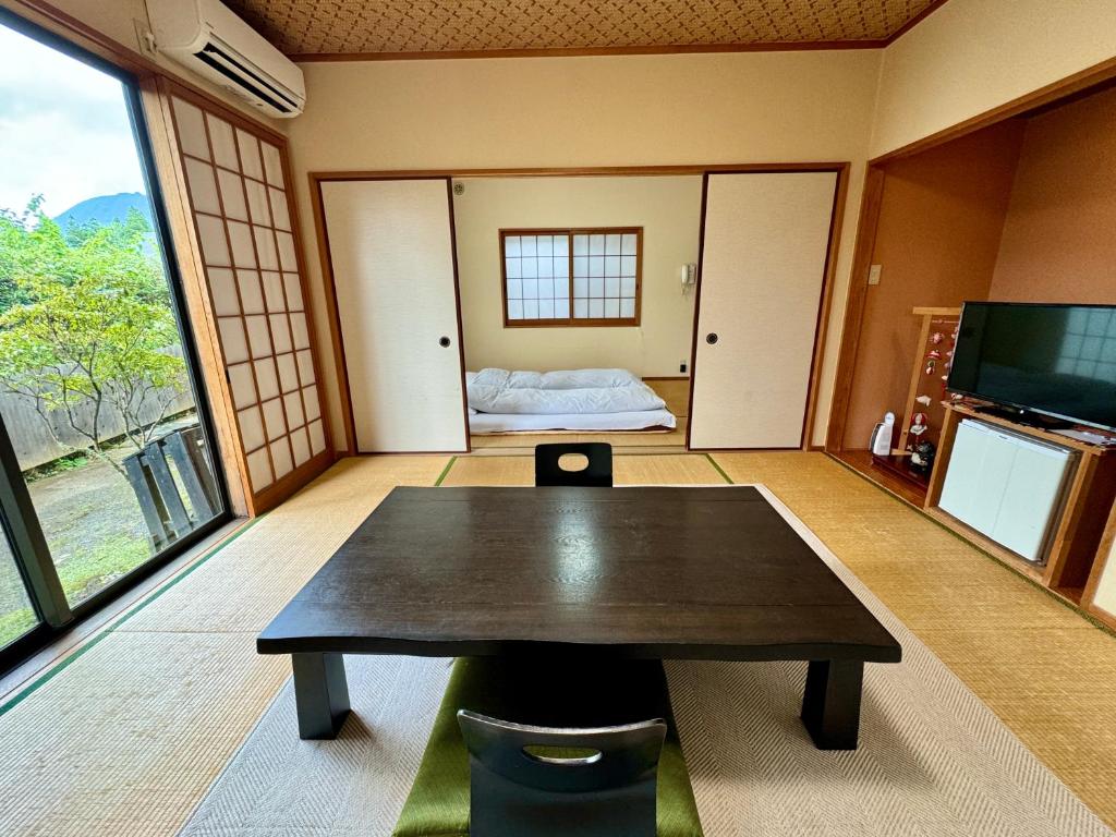 une chambre avec une table et une chambre avec un lit dans l'établissement Oyado Tamayura 18 years or older, à Yufu