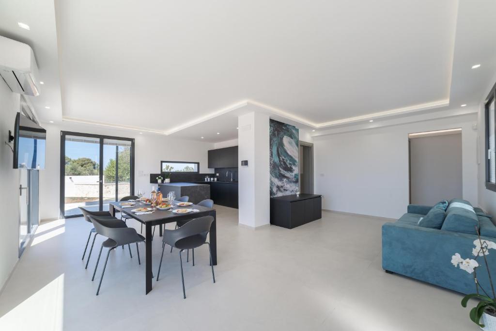 une salle à manger et un salon avec une table et des chaises dans l'établissement Villa Lorenbea by salentoltremare, à Castrignano del Capo