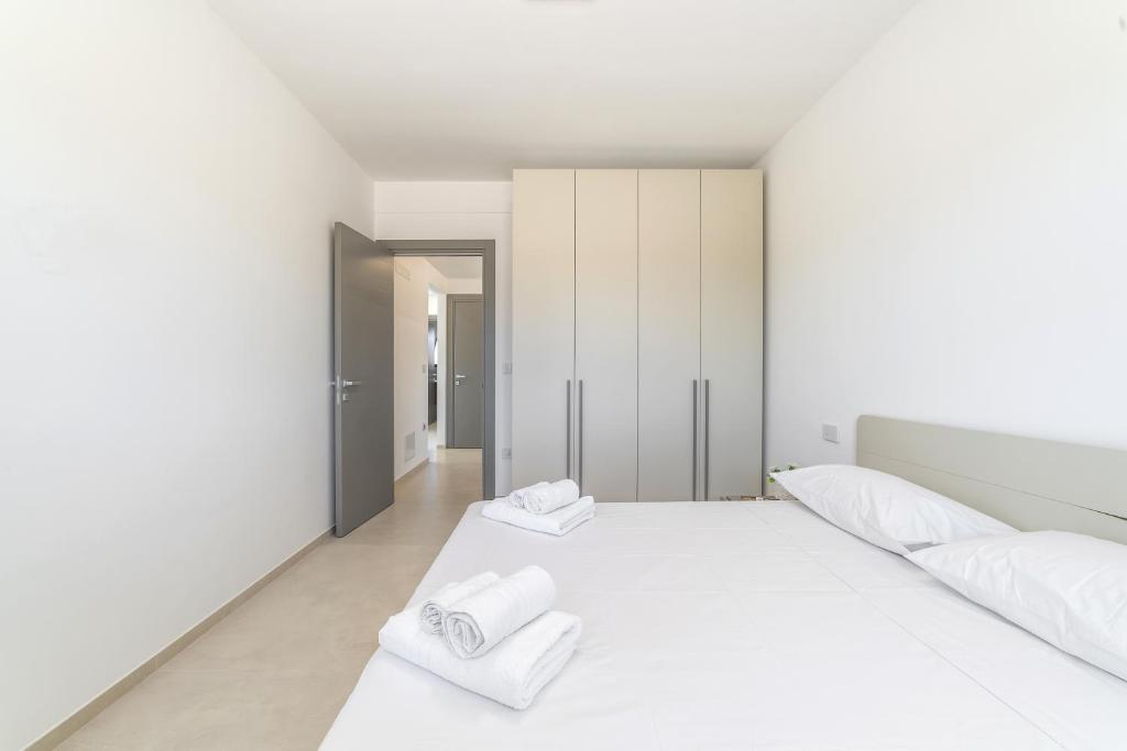 - une chambre blanche avec 2 serviettes blanches sur un lit dans l'établissement Villa Lorenbea by salentoltremare, à Castrignano del Capo