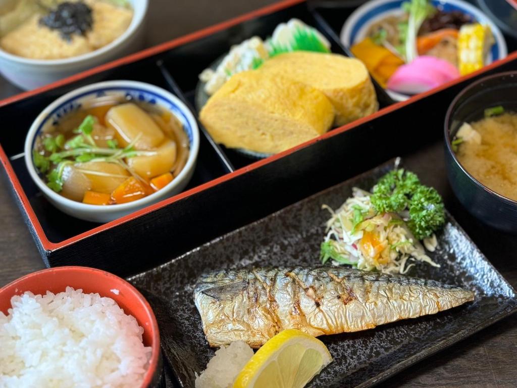 un plateau de nourriture avec du poisson, du riz et d'autres aliments dans l'établissement Oyado Tamayura 18 years or older, à Yufu