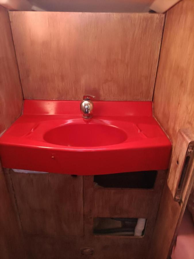 un lavabo rouge avec un comptoir rouge dans une salle de bain dans l'établissement nuit insolite sur un bateau, à Canet 3 autres photos