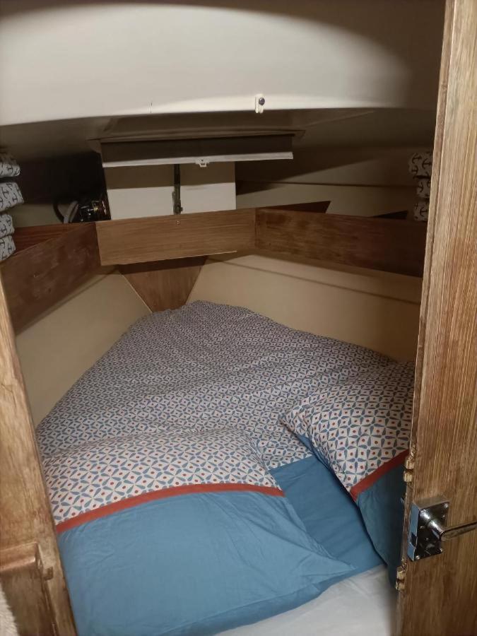 Ce lit se trouve dans un dortoir doté d'un cadre en bois. dans l'établissement nuit insolite sur un bateau, à Canet