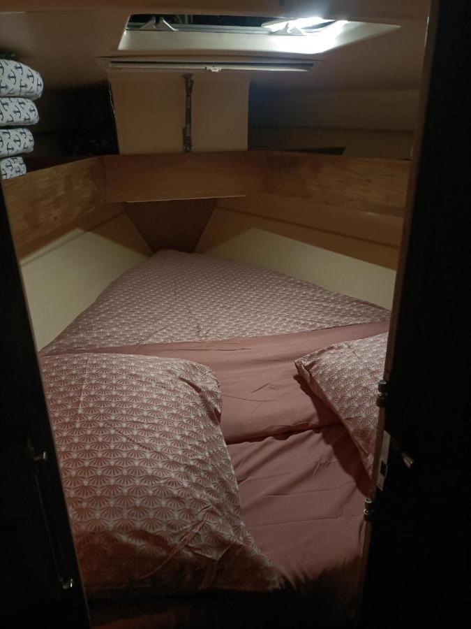 une petite chambre avec un lit dans une petite pièce dans l'établissement nuit insolite sur un bateau, à Canet