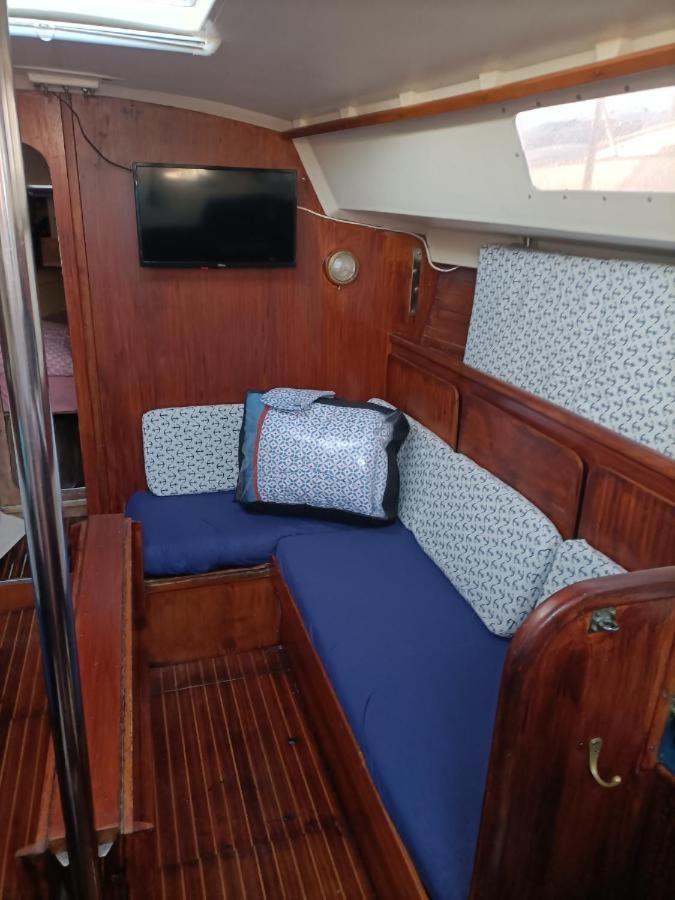 un petit bateau avec un lit bleu à l'arrière dans l'établissement nuit insolite sur un bateau, à Canet