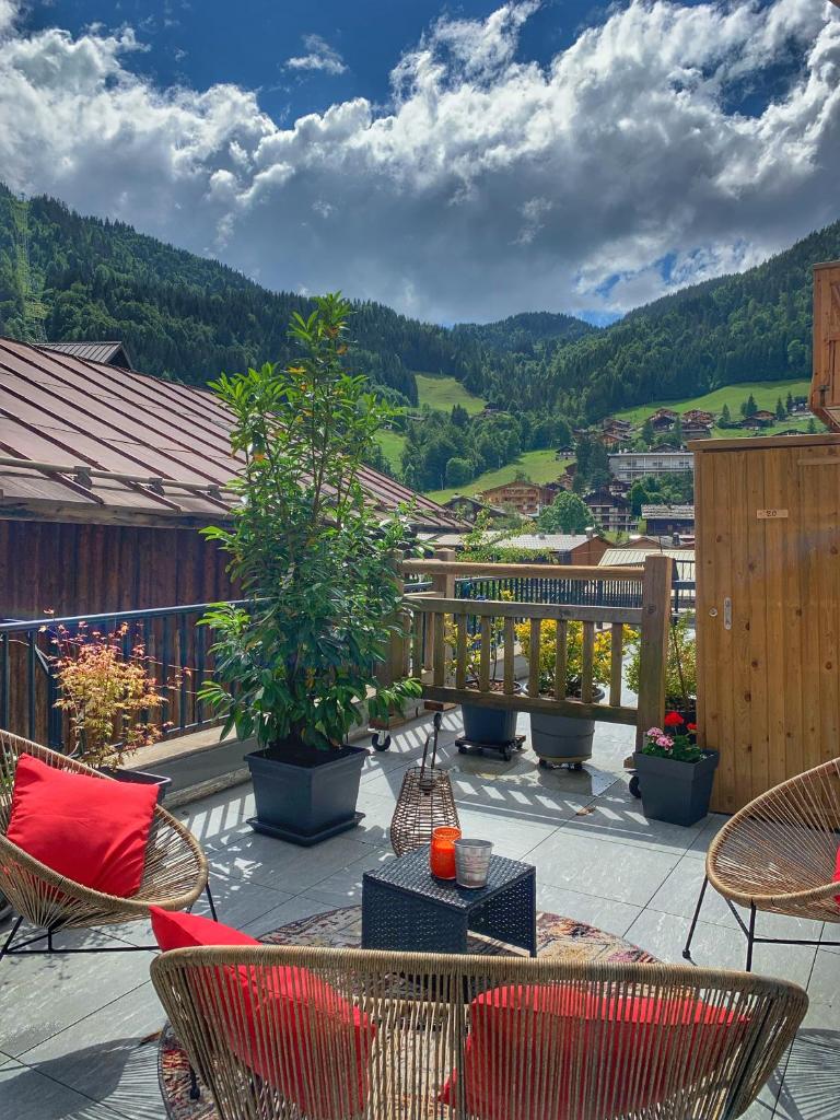 d'une terrasse avec des chaises et des tables sur un balcon. dans l'établissement Nouveau et spacieux, Place de l'Eglise et terrasse privative, à La Clusaz