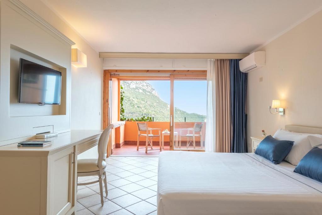 Cette chambre comprend un lit, un bureau et un balcon. dans l'établissement Boutique Hotel Torre Di Cala Piccola, à Porto Santo Stefano 242 autres photos