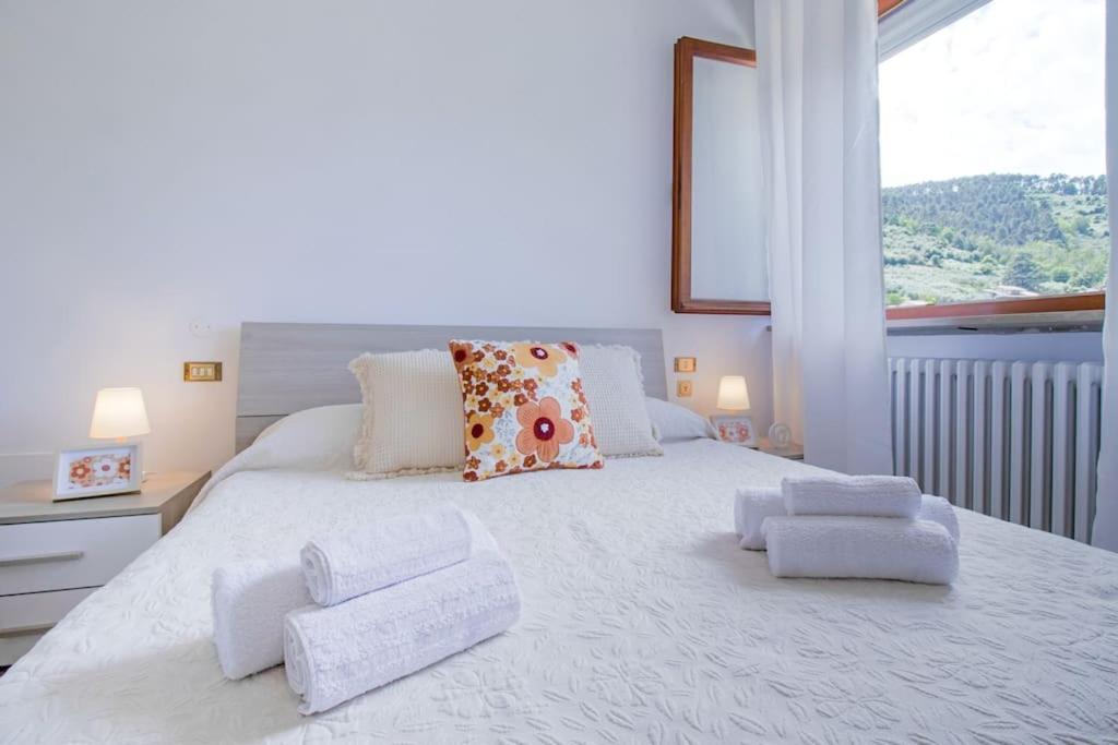 une chambre avec un grand lit blanc avec une fenêtre dans l'établissement Villa Asmara Piscina AC WI-FI Park, à Capannori