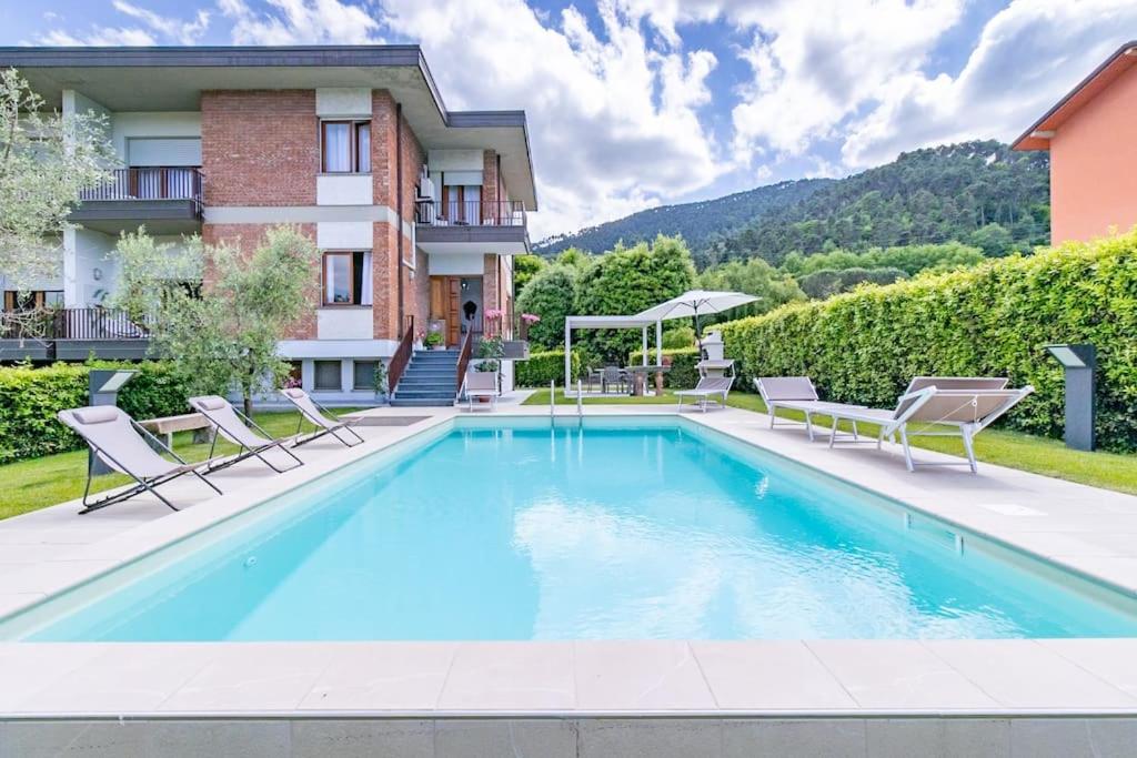 une piscine avec des chaises et un bâtiment dans l'établissement Villa Asmara Piscina AC WI-FI Park, à Capannori