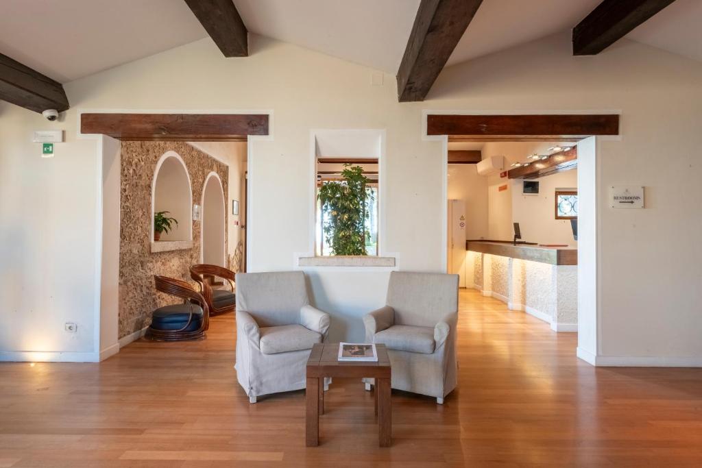 un salon avec deux chaises et une table dans l'établissement Boutique Hotel Torre Di Cala Piccola, à Porto Santo Stefano