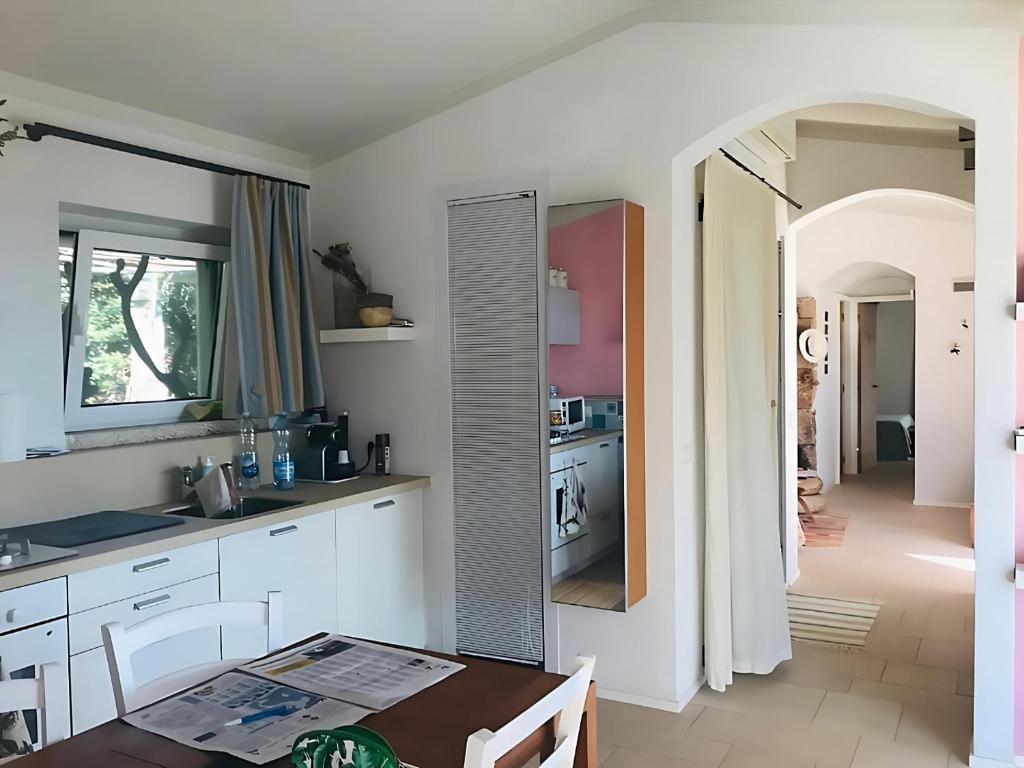 une cuisine avec des armoires blanches et une table à l'intérieur dans l'établissement Villa il Capriccio, à Conca Verde