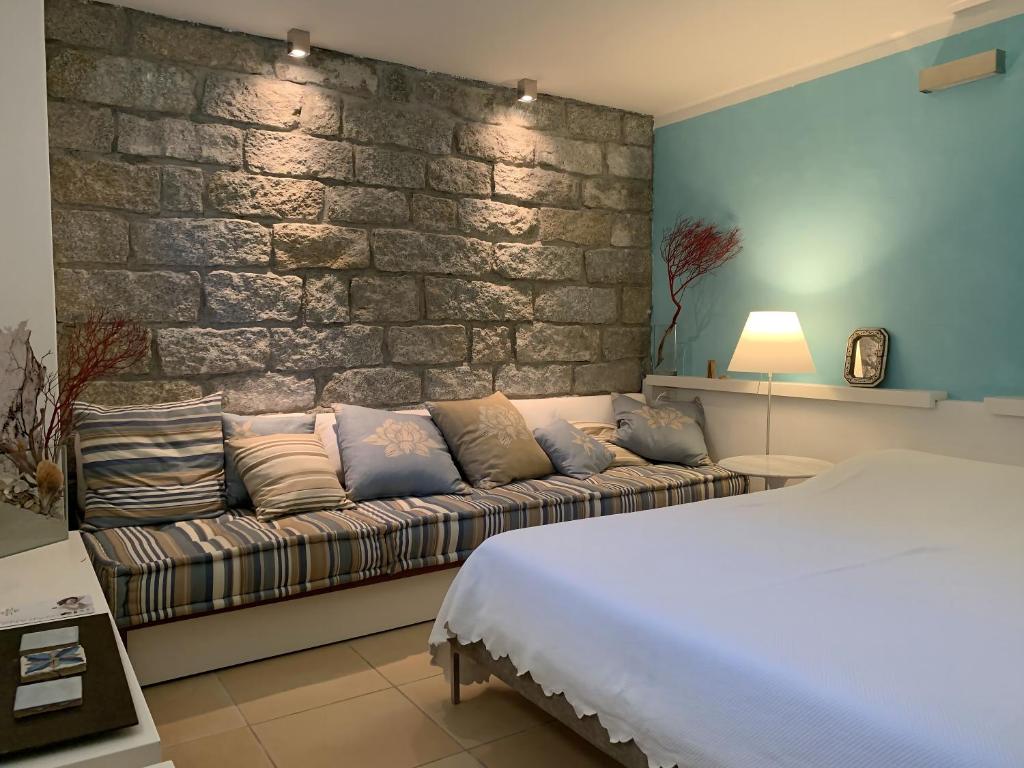 - une chambre avec un canapé et un mur en briques dans l'établissement Villa il Capriccio, à Conca Verde