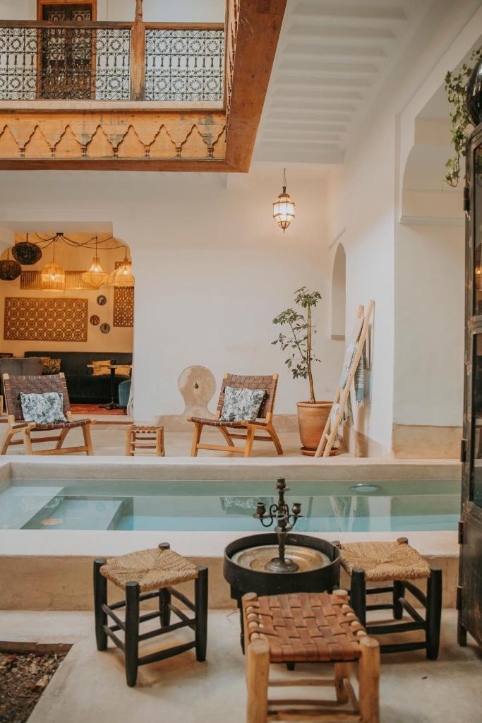 Cette chambre dispose d'une piscine avec des chaises et une table. dans l'établissement Riad Djebel, à Marrakech