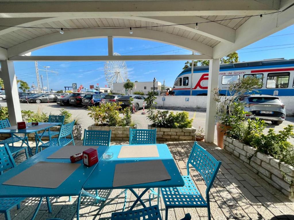 une table bleue et des chaises avec un train sur un parking dans l'établissement B&B Marina Sleep And Ship, à Rodi Garganico