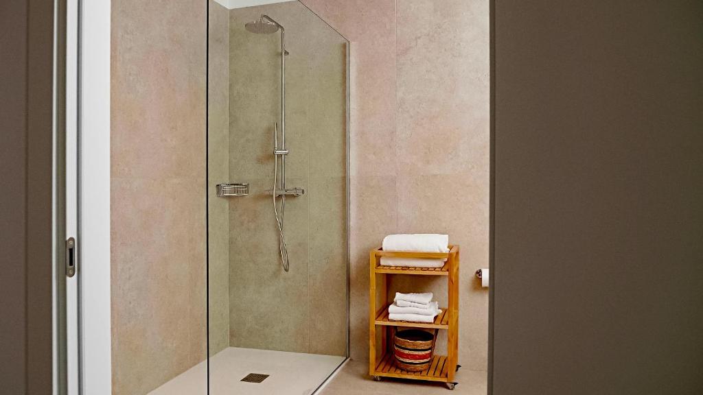 une douche avec une porte vitrée dans une salle de bain dans l'établissement Residence Duna Rossa - Family Friendly, à Duna Verde