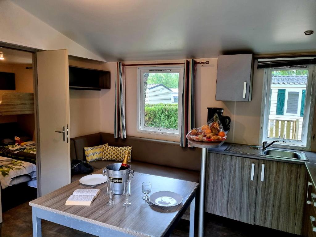 - une petite cuisine avec une table dans une petite maison dans l'établissement Parc de Nibelle, à Nibelle