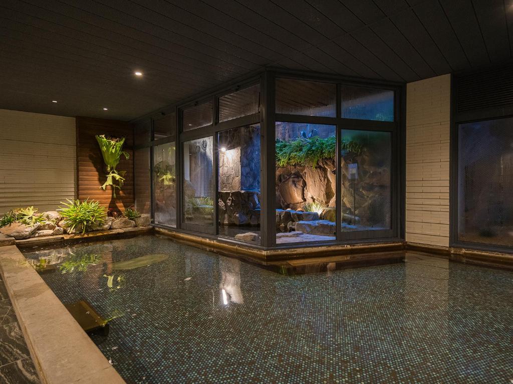une piscine intérieure avec un aquarium dans une maison dans l'établissement Irifuneso, à Ureshino