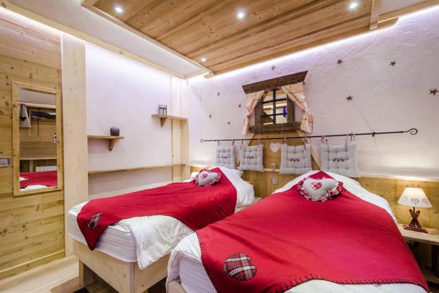 - 2 lits dans une chambre avec des draps rouges et blancs dans l'établissement Chalet l'Avalin, à Val dʼIsère