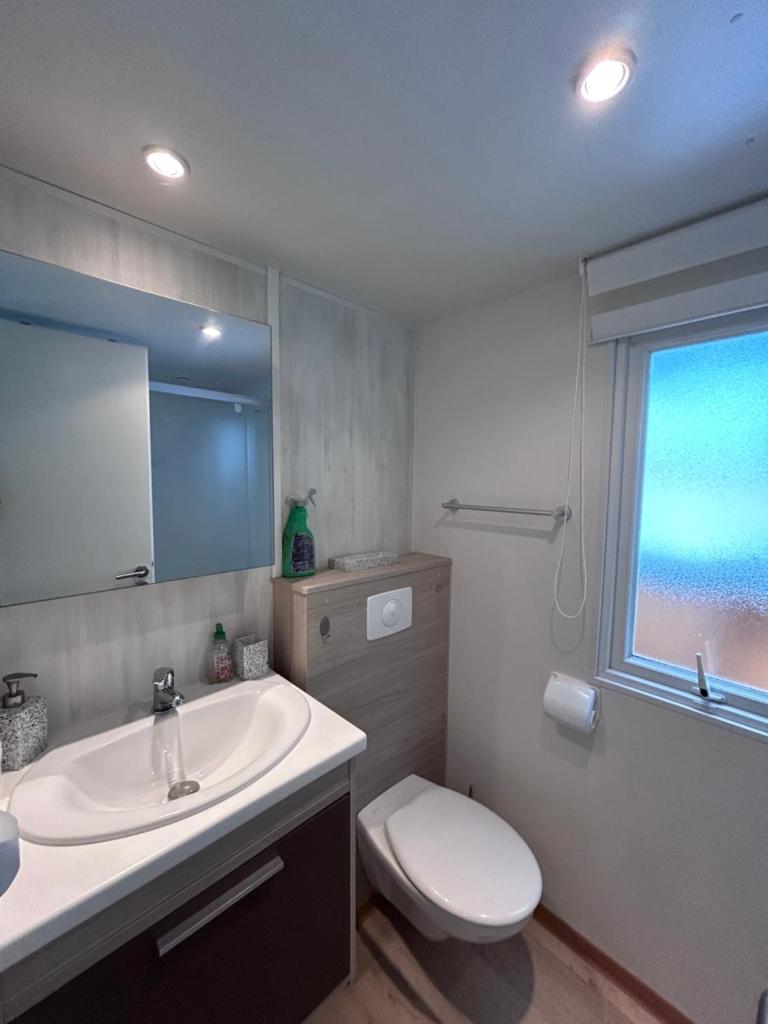 une salle de bain avec un lavabo et des toilettes et une fenêtre dans l'établissement Camping Happy Pyrénées, à Saligos 37 autres photos