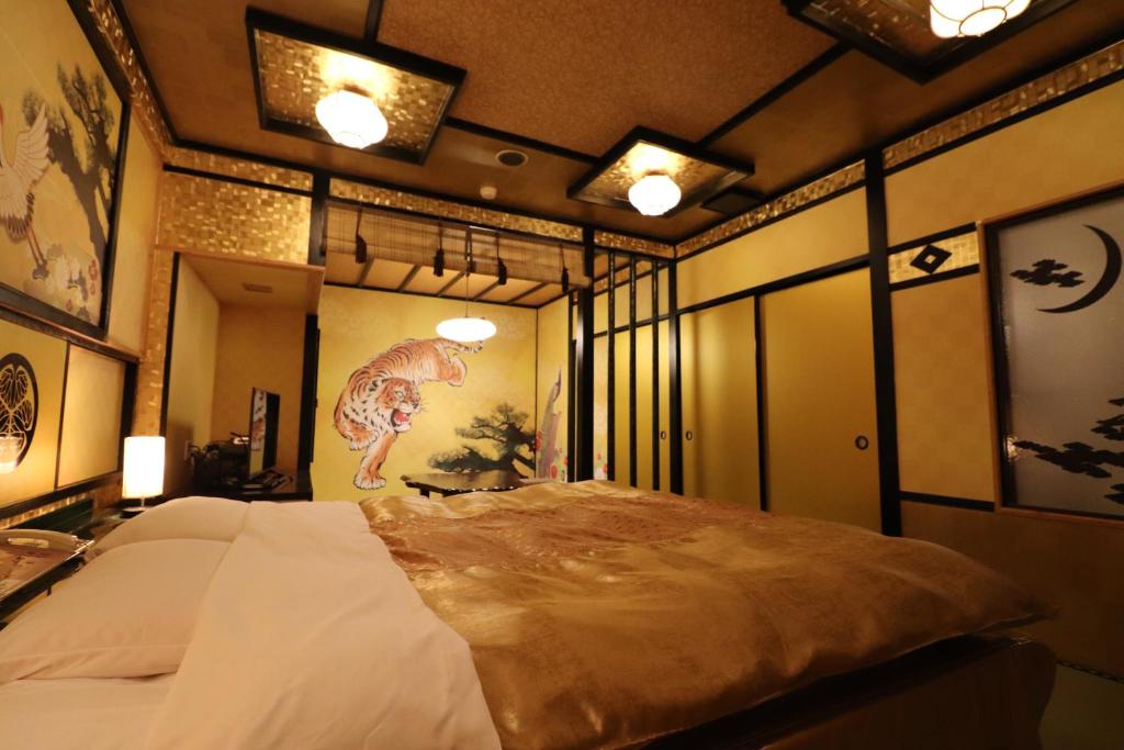 une chambre avec un grand lit et un tableau au mur dans l'établissement ホテル三愛, à Himeji