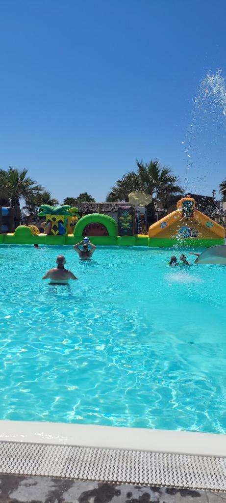 un groupe de personnes nageant dans une piscine dans l'établissement Mobil home Camping Bleu Marine, à Sérignan 22 autres photos