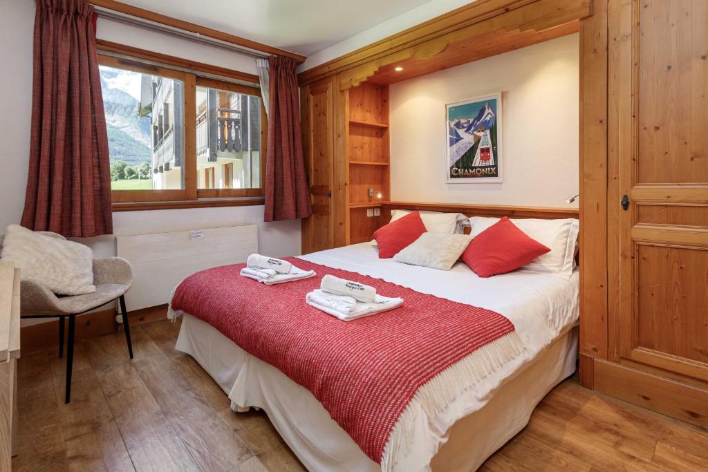 une chambre avec un lit avec une couverture rouge dans l'établissement Les Balcons du Savoy 104 appt - Chamonix All Year, à Chamonix-Mont-Blanc