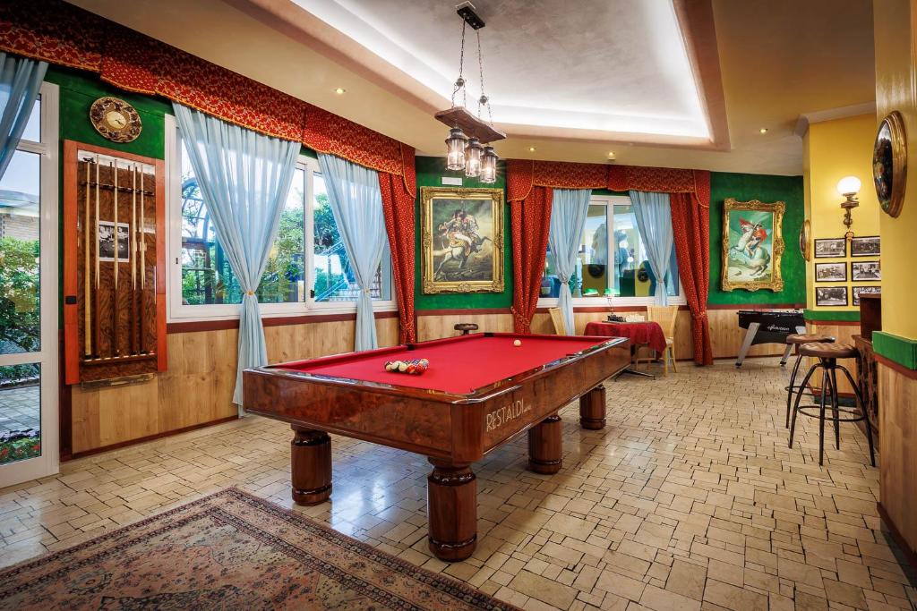 une salle de billard avec un billard rouge dans l'établissement Hotel Napoleon, à Lido di Jesolo