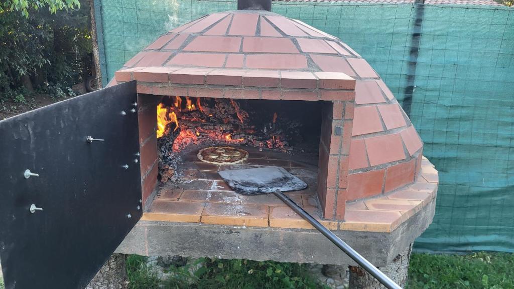 - un four en briques avec une pizza à l'intérieur dans l'établissement La Yourte, à Vinassan