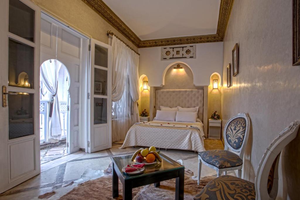 une chambre avec un lit et une table avec un bol de fruits dans l'établissement RIAD DREAMS, à Marrakech 37 autres photos