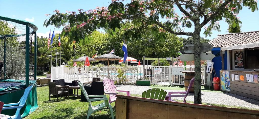 un groupe de chaises assises dans une cour dans l'établissement eco lodge 4 etoiles cotton prenium, à Vendays-Montalivet