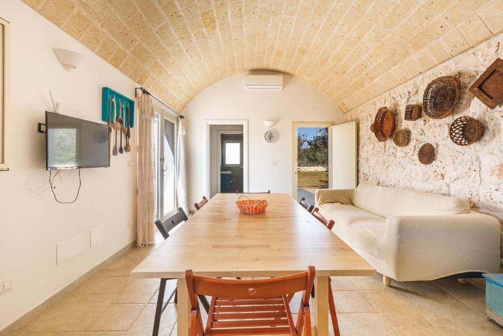 un salon avec un canapé et une table dans l'établissement Trullo Fico by Perle di Puglia, à San Michele Salentino