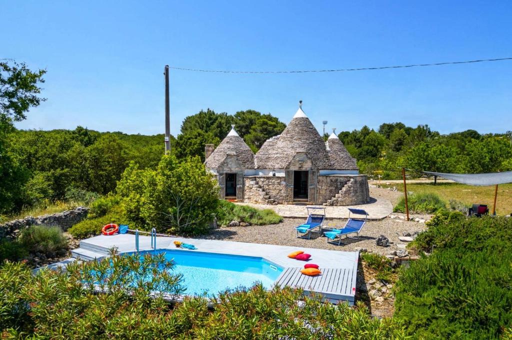 une maison en pierre avec une piscine dans une cour dans l'établissement Villa Trullo Selva Piccolo by Villa Plus, à Martina Franca