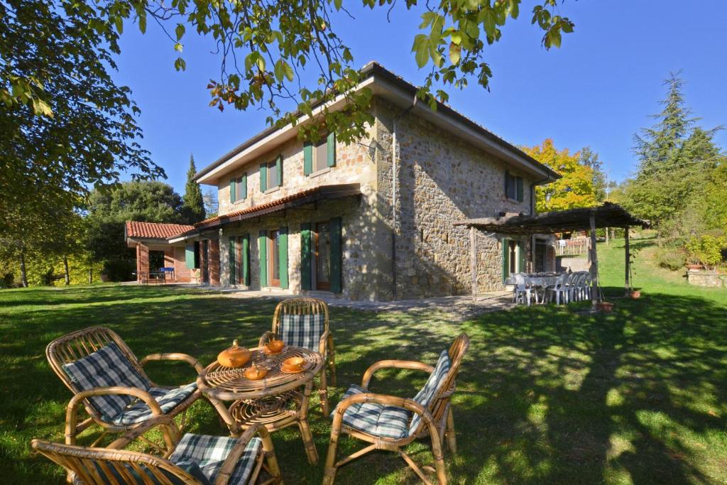 une table et des chaises devant une maison en pierre dans l'établissement Casale Tigli - Happy Rentals, à Capolona