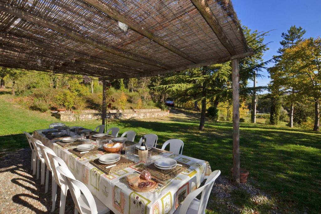 une table et des chaises sous une pergola dans l'établissement Casale Tigli - Happy Rentals, à Capolona