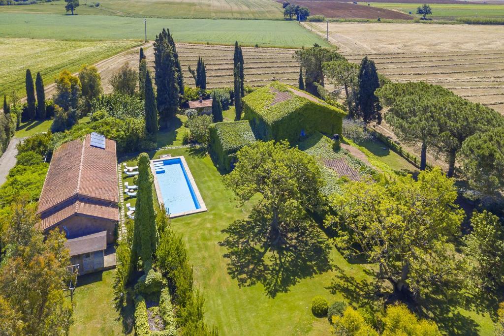 Cette chambre offre une vue sur une maison dotée d'une piscine et d'arbres. dans l'établissement Casale Teresa - Happy Rentals, à Tarquinia