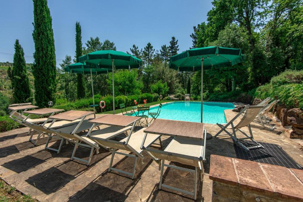 - un groupe de chaises longues et de parasols à côté de la piscine dans l'établissement Villa Casacheta - Happy Rentals, à Montaione