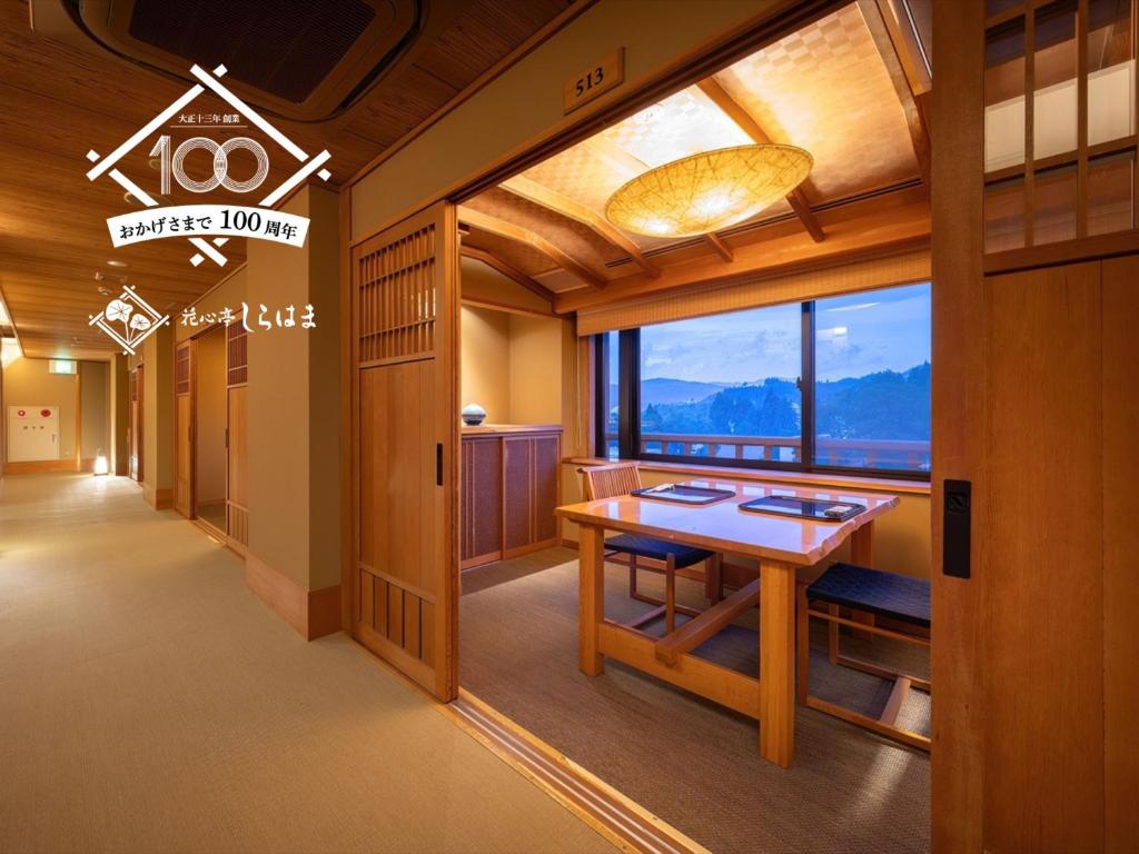 une salle à manger avec une table et une grande fenêtre dans l'établissement Kashintei Shirahama, à Senboku
